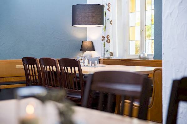 Blick in den modernen aber dennoch gemütlich rustikal angehauchten Gastraum mit Holzmöbeln.