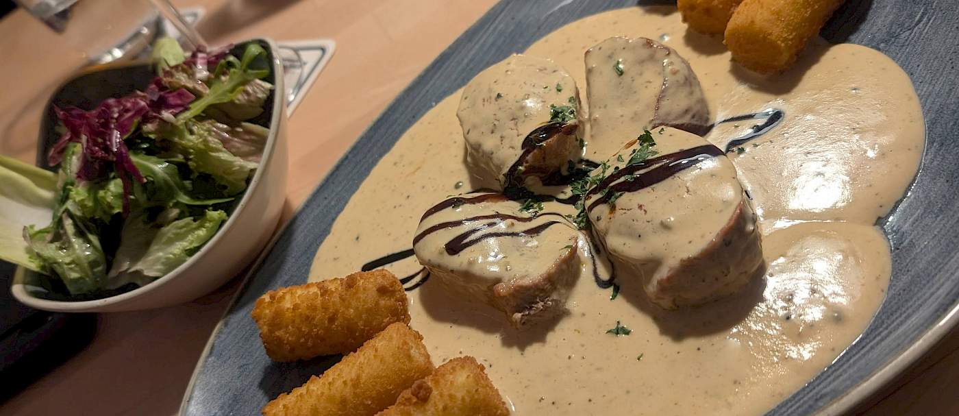 Schweinemedallions mit Kroketten und Pfefferrahmsoße.